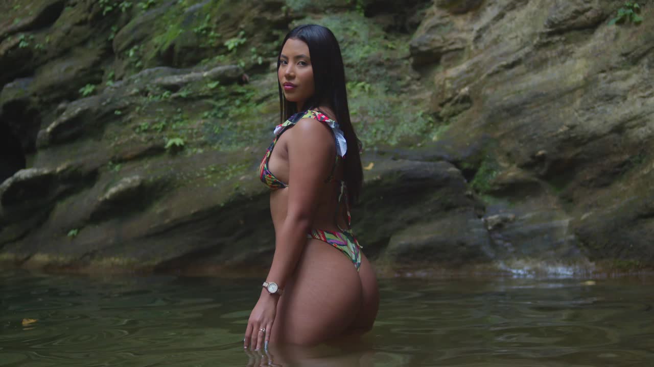 Presso una bellissima cascata caraibica, una ragazza in bikini