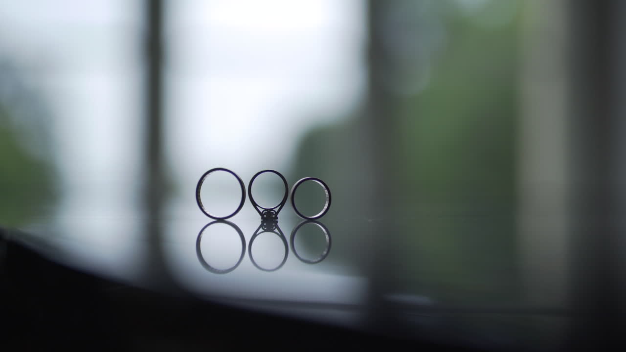 Wedding and Engagement Rings Reflecting on a Dark Surface