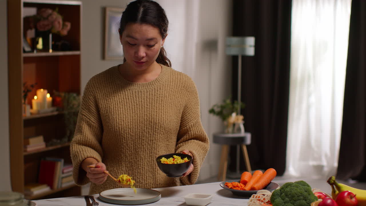 가정에서 부에서 여성이 오르조 파스타와 구운 토마토로 건강한 채식주의 또는 채식주의 식사를 준비하고 있습니다.