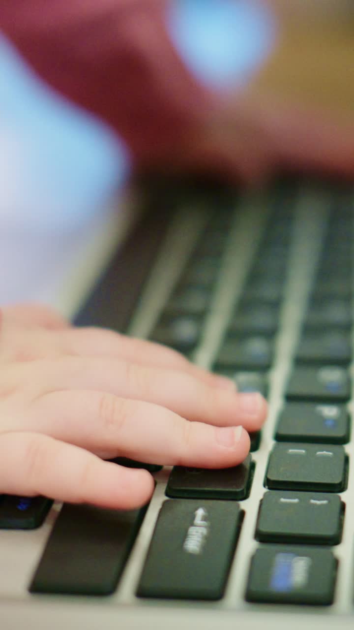 Little Hands at Play: A Child's Fascination with Typing on a Laptop Keyboard, Showcasing Curiosity and Early Exploration of Technology in Soft Focus