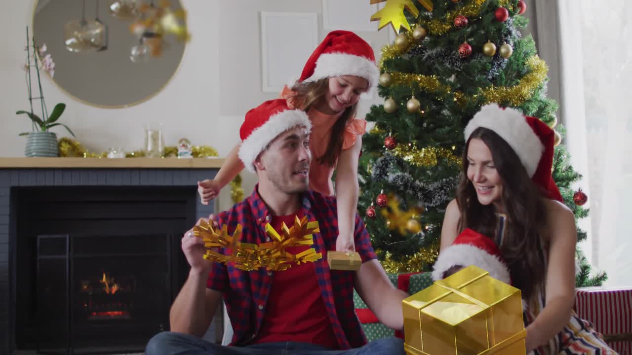 animación de felicitaciones de navidad texto con pareja con niños en sombreros de papá noel en navidad