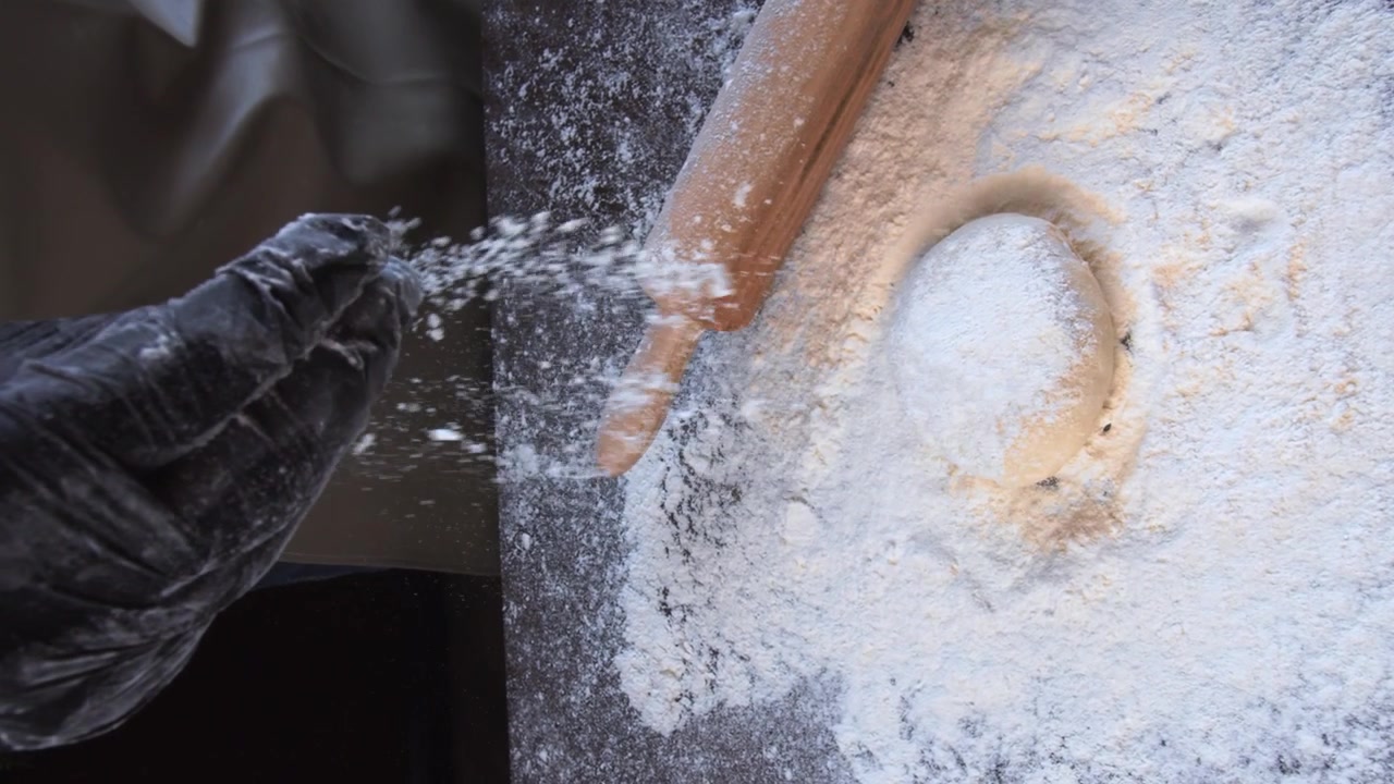 spraying flour on the table in the bakery vertical shot