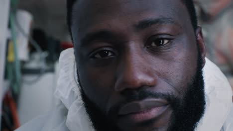 weary black paramedic taking off protective accessories tired african american doctor taking off face shield and mask and looking at camera while working in 911 service during epidemic