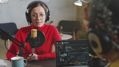 woman giving interview to podcast presenter in studio