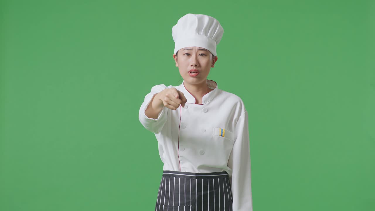Asian Woman Chef Shouting To Camera While Standing In The Green Screen Background Studio