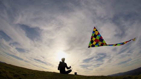child flying a colorful kite in a field