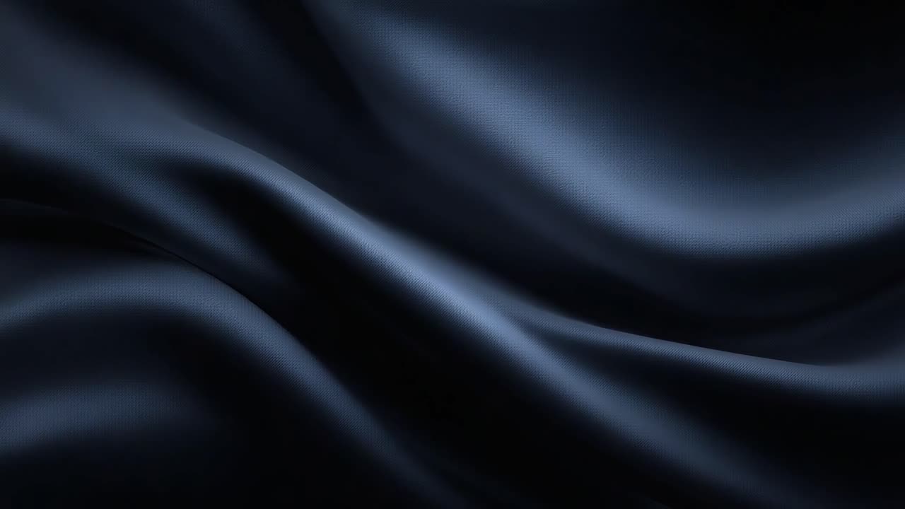 Tessuto scuro, liscio e luccicante: un'elegante dimostrazione di texture setosa e movimento fluido catturati in ricchi toni di nero che evocano un senso di lusso e profondità