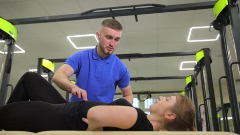 physical therapist assessing patient in gym