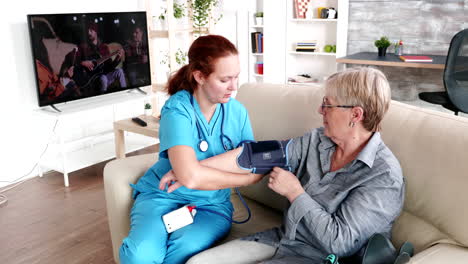 enfermera midiendo la presión arterial de una anciana