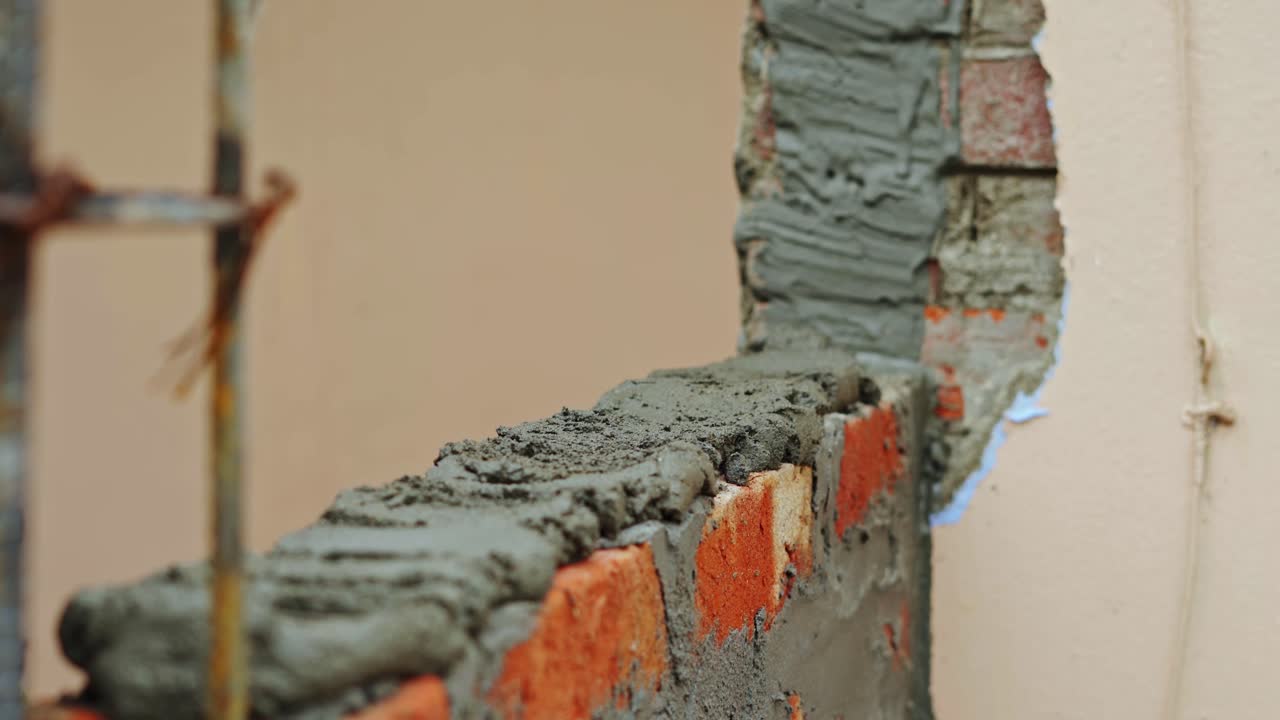 edificio de pared en el sitio de construcción de cerca poniendo cemento en la pared de ladrillos