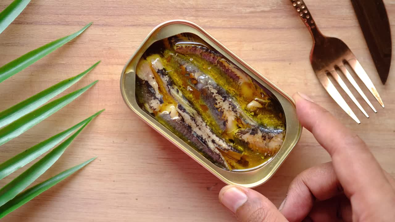 mano con una lata de sardinas