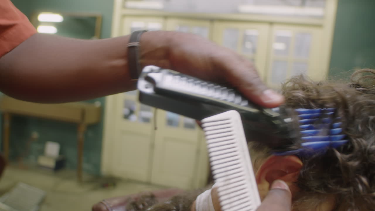 Barber Giving Haircut with Hair Clippers and Comb