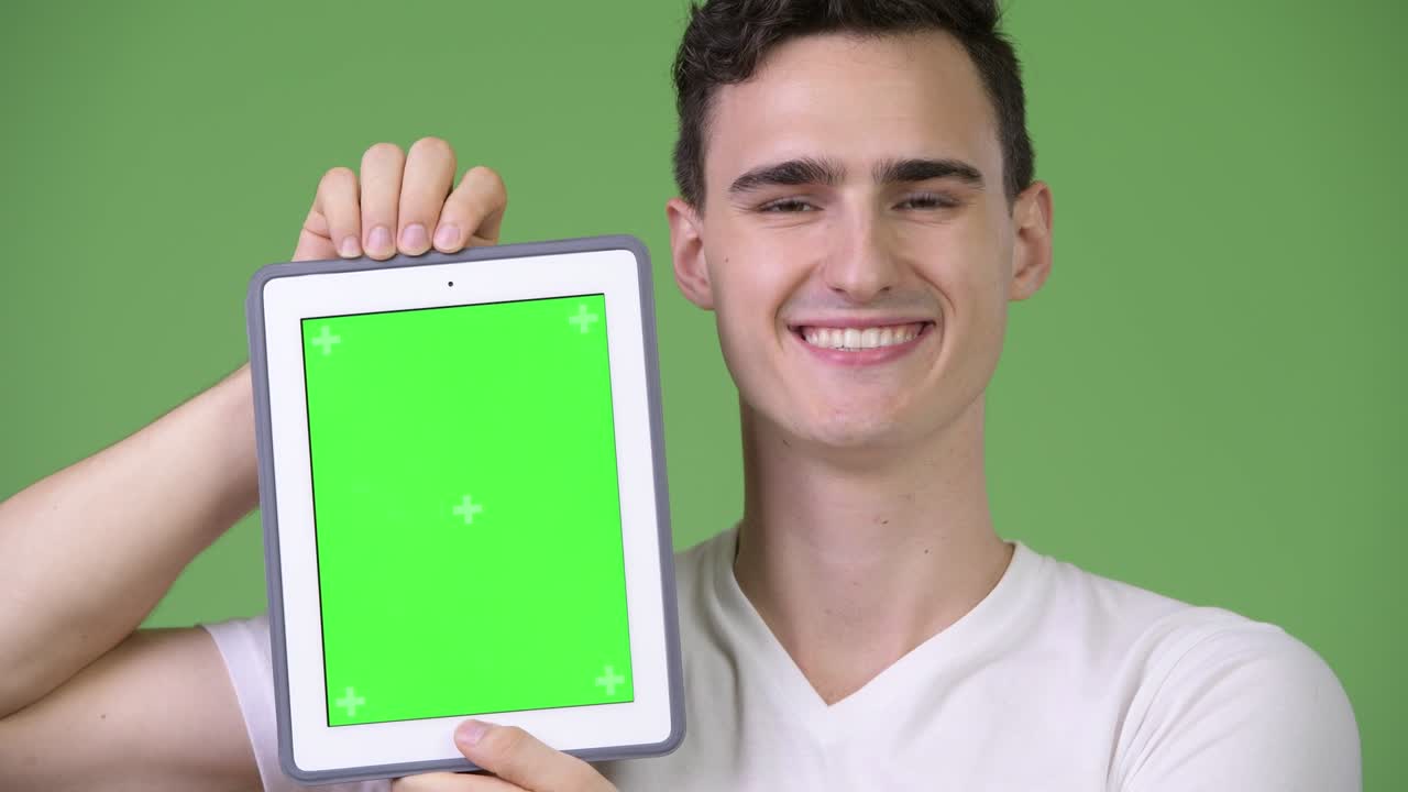 Young handsome man showing digital tablet