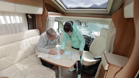 parejas en autocaravanas mirando el mapa local para el viaje.