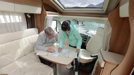 couples in rv camper looking at the local map for the trip.