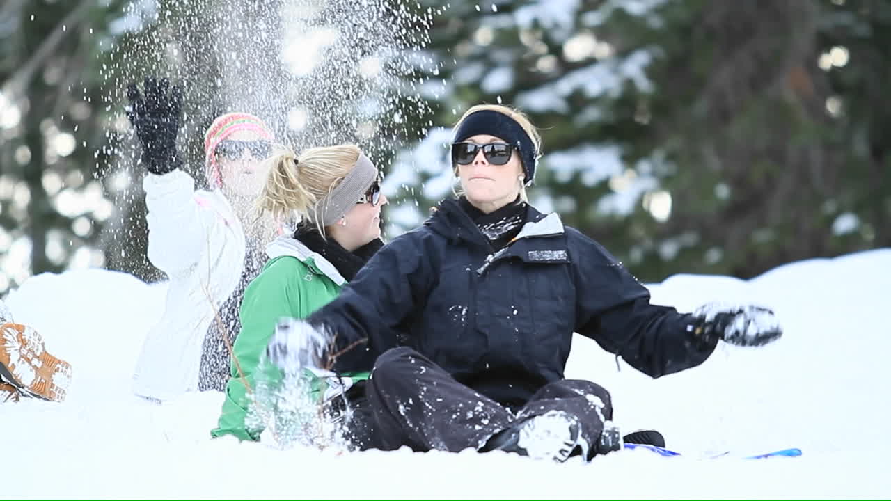 스키장에서 젊은 여성들이 눈을 공중에 던지다