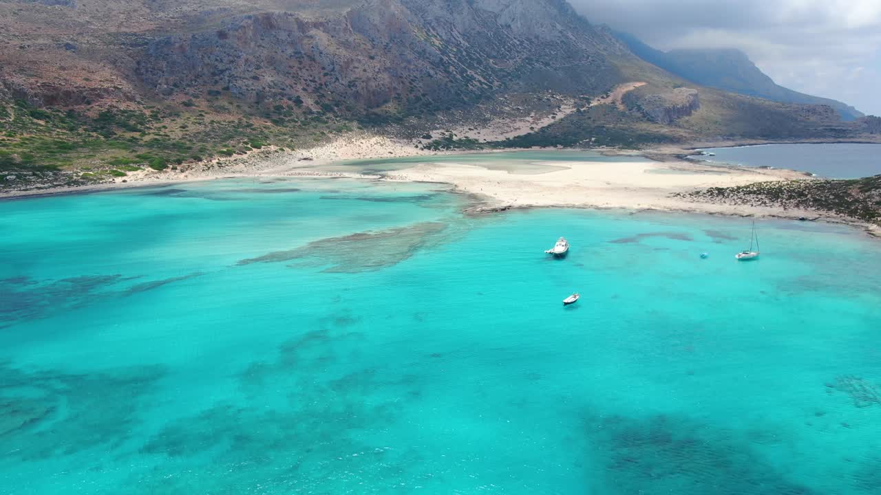 Balos Beach in Crete Greece with turquoise waters and tourist transport ship with raft, Aerial dolly in shot