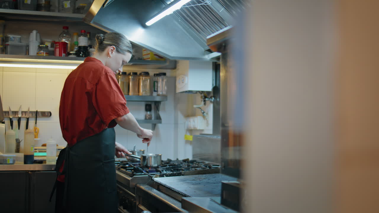 Young professional cooking stove kitchen catering establishment. Woman preparing