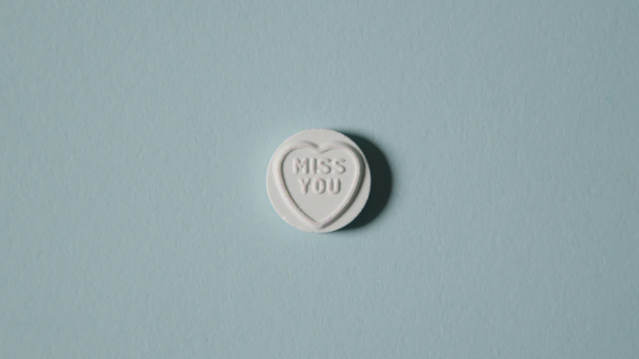 파란 배경에 당신이 그리워요 메시지와 함께 심장 사탕을 손에 들고