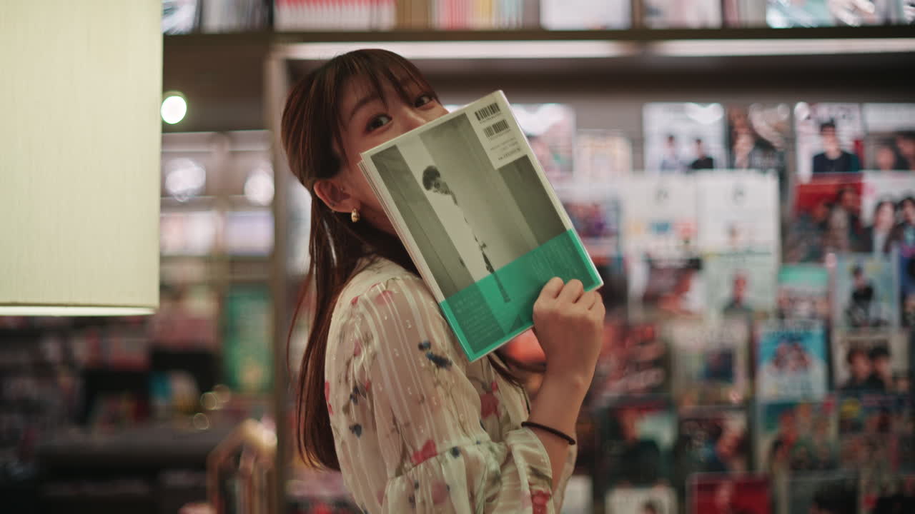 Woman hiding behind a book in a bookstore