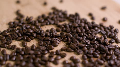 pila de granos de café en la superficie de madera vuelo lento sobre 01