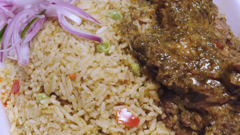 primer plano del plato peruano &quot;arroz con pato&quot; en un bol