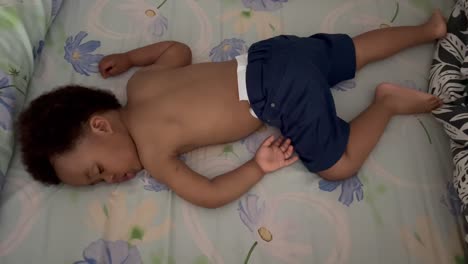 niño lindo de dos años durmiendo siesta de verano en una tarde calurosa