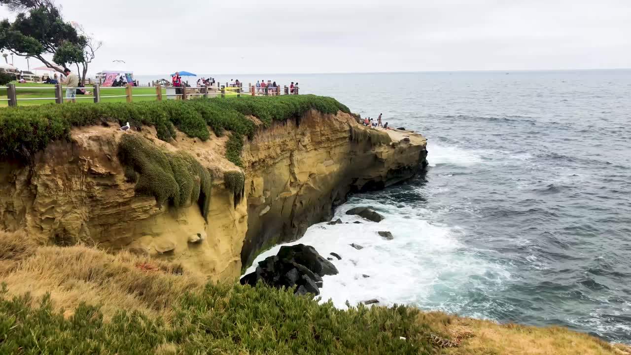 사람들은 샌디에이고 근처의 햇살 가득한 캘리포니아 해변을 즐깁니다.