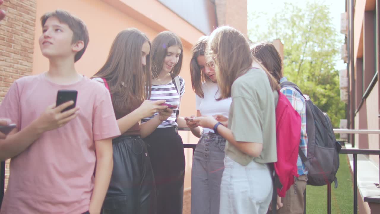 las adolescentes se divierten y conversan usando sus teléfonos móviles