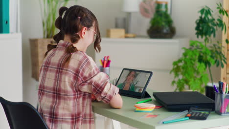 a student talks to the teacher on a tablet during online tutoring