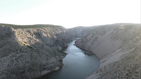 Drone-flight-over-a-tourist-standing-on-the-edge-of-a-cliff-in-the-Zrmanja-gorge-in-Jasenice,-Zadar-County,-Croatia