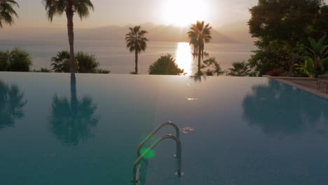 Piscina-En-El-Complejo-Con-Vistas-Al-Mar-Y-A-Las-Montañas-Al-Atardecer