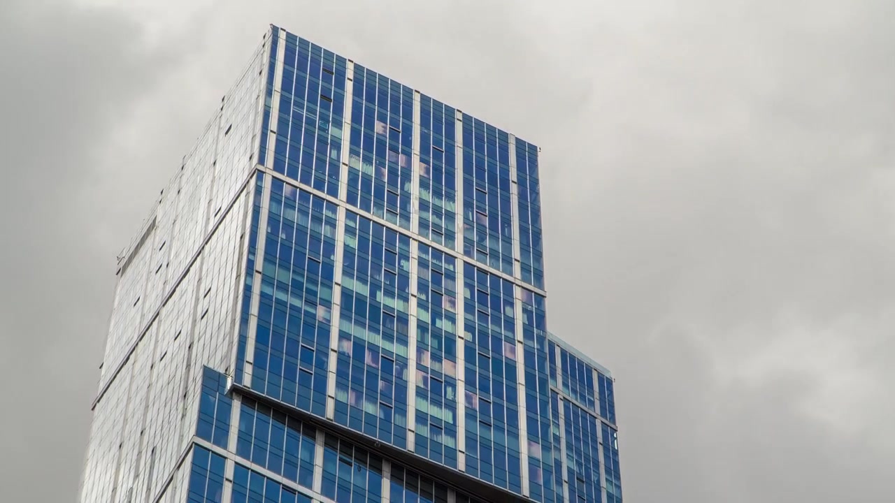 Rascacielos de Moscow-City (timelapse) con reflejos en la superficie de cristal. Oficinas de negocios, edificios corporativos en Moscú, Rusia. Cielo azul nublado de fondo