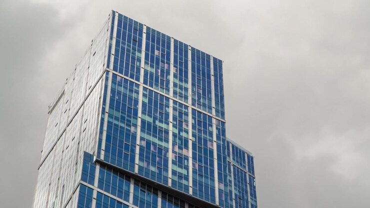Grattacieli di Moscow-City in timelapse con riflessi su superficie di vetro. Uffici commerciali, Edifici aziendali a Mosca, Russia. Cielo blu nuvoloso sullo sfondo.