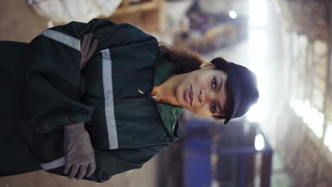 retrato de una mujer afroamericana en un uniforme verde especial contra el fondo del interior de un procesamiento de residuos