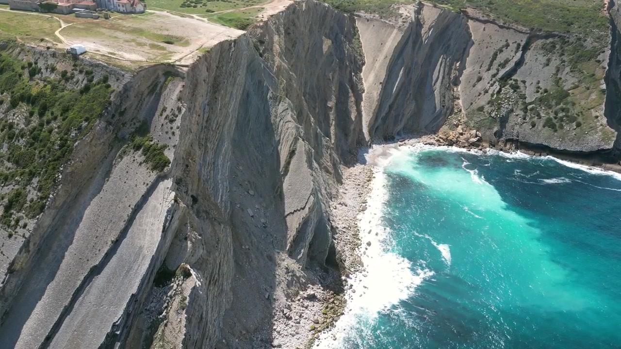 Aerial drone footage of Cabo Espichel, Portugal: dramatic Atlantic cliffs, rugged coastline and vast ocean landscape under natural light. Ideal for travel and nature projects.