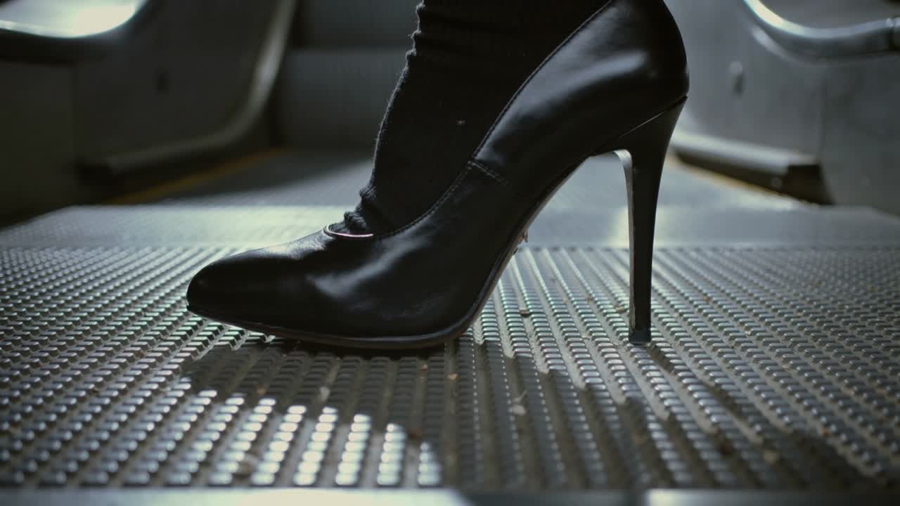 Zwarte stiletto en kous van de draagster laten zakken op de bezaaide vloer van de bus na gewichtsverplaatsing voor evenwicht