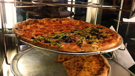 delicious italian pizza spinning around in a glass display hot and ready to eat