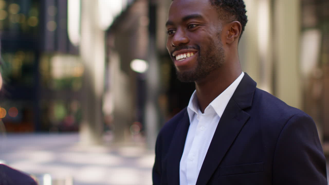 un hombre de negocios y una mujer de negocios se estrechan las manos fuera de las oficinas en el distrito financiero de la ciudad de londres, reino unido.