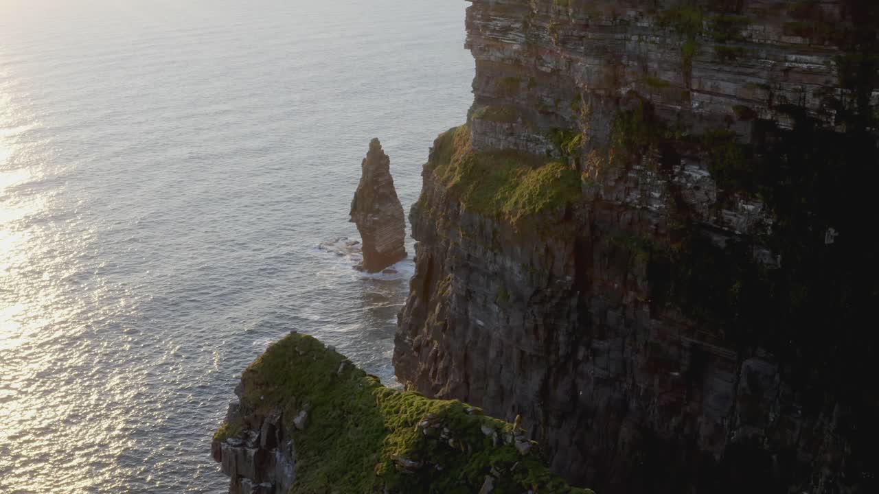 puesta de sol tranquila en los acantilados de moher con pájaros volando a lo largo de los acanalados y la pila de mar