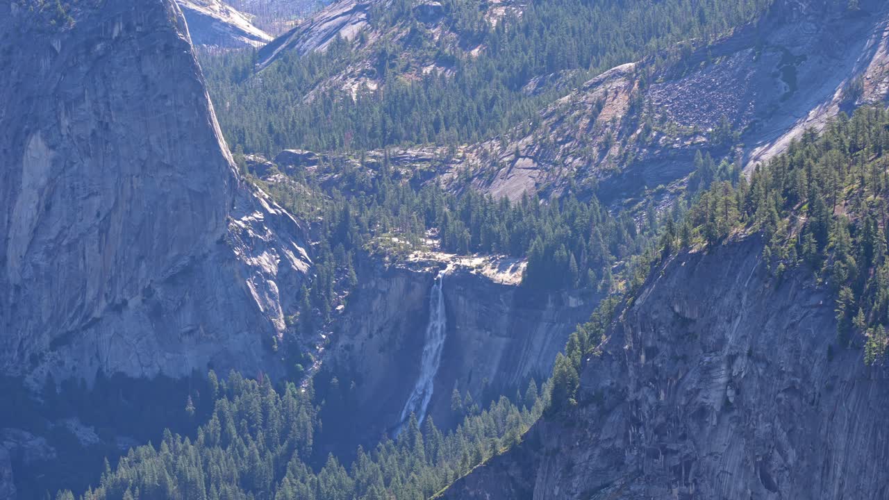 Footage capturing the majestic Nevada Falls waterfall from the elevated vantage point of Glacier Point in Yosemite National Park, California.