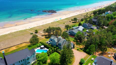aerial drone clip of a maine beach house. large windows, deck, yard, and ocean views make this beautiful real estate perfect for relaxing seaside living or vacation fun in new england