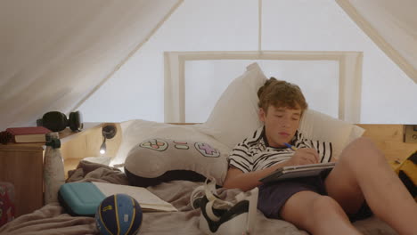 teenager studying in a cozy tent bedroom