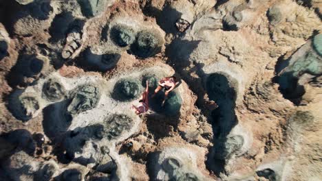 aerial view of eroded rocky landscape with tide pools and people