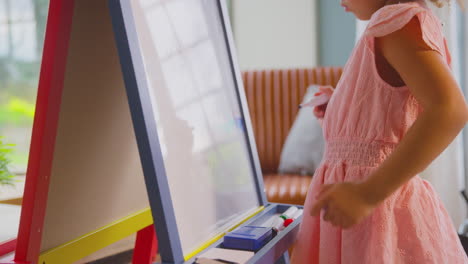 close up of girl drawing picture on whiteboard at home