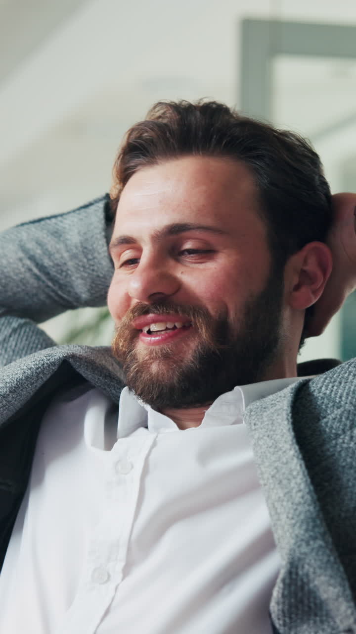 Smiling Bearded Man Relaxing with Hands Behind Head