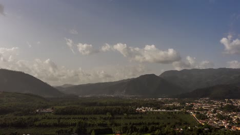 aerial, drone hyperlapse moviéndose rápido frente a los campos y las montañas durante la puesta de sol en 4k