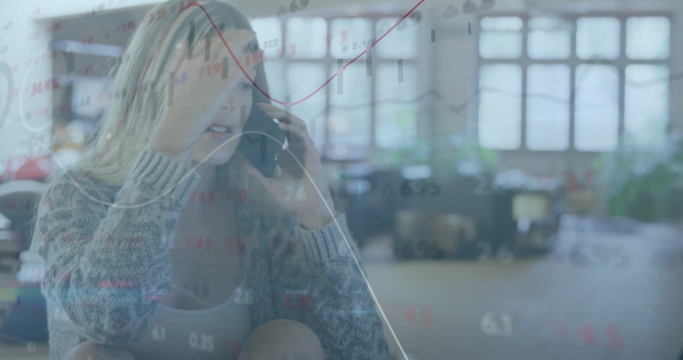Office professional initiating phone call and interpreting live finance charts sweeping workspace