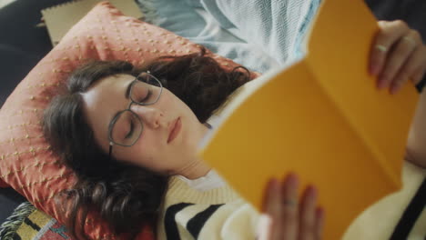 girl lying on sofa and reading book