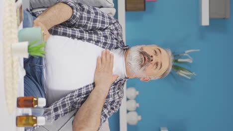 vídeo vertical de un anciano con dificultad para respirar está respirando duro.